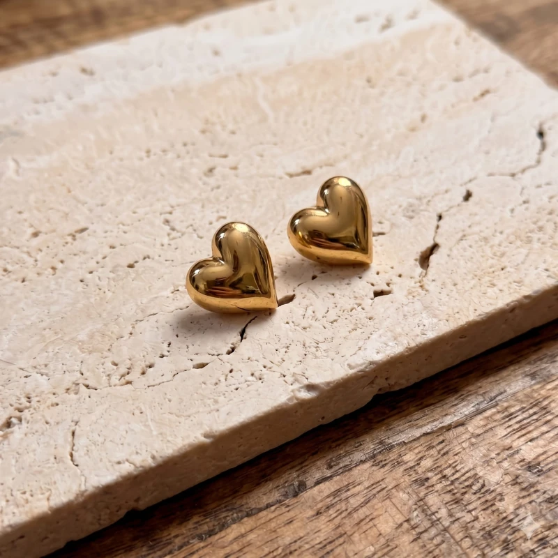 Shiny_gold_heart-shaped_earrings_resting_202606241123 (1).jpeg