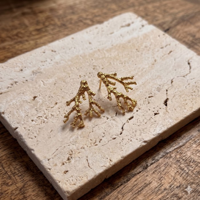 Intricate_gold_coral-shaped_earrings_resting_202606241126.jpeg