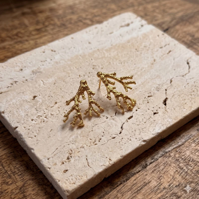 Intricate_gold_coral-shaped_earrings_resting_202606241126.jpeg